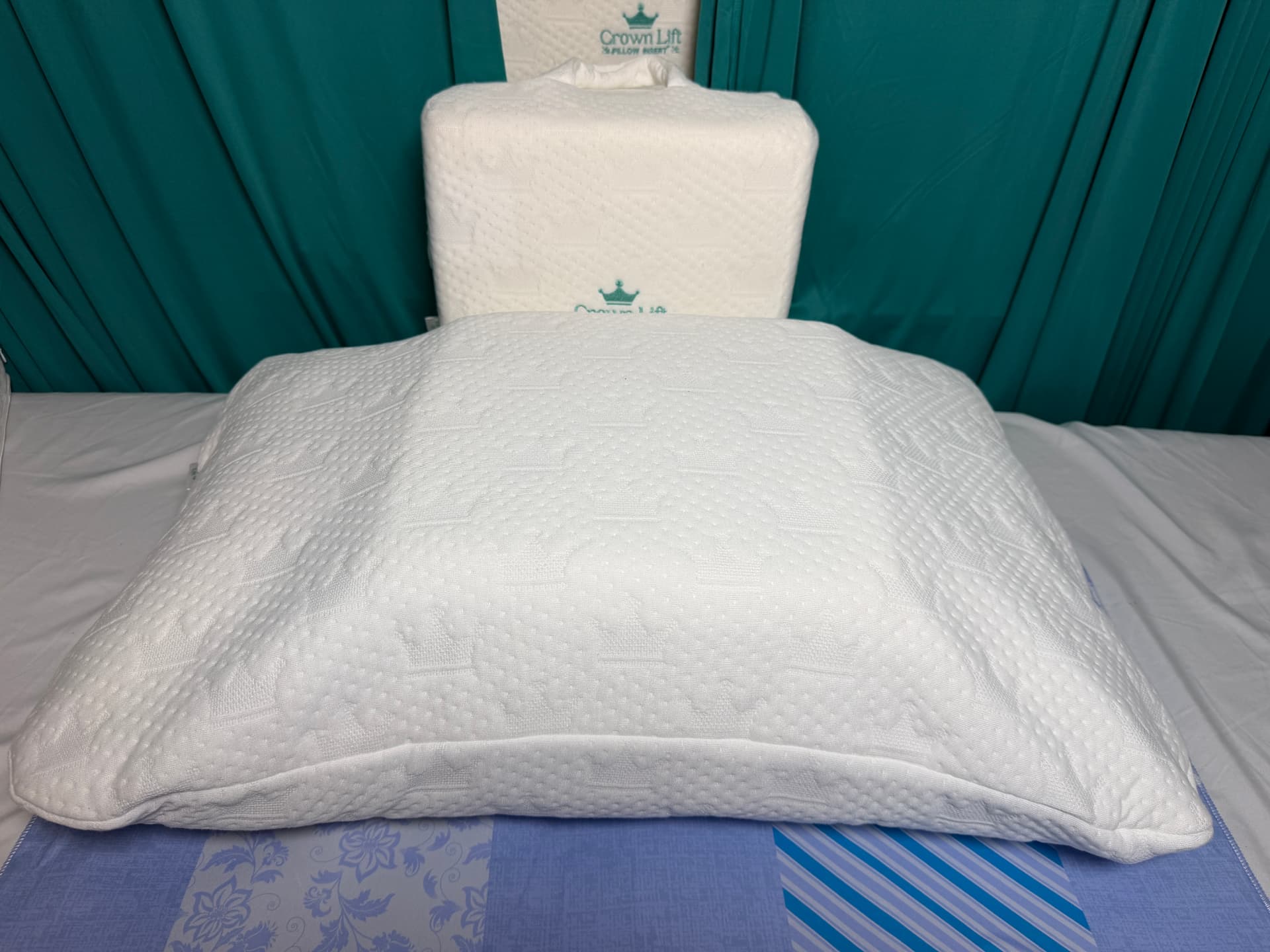 The Crown Lift pocket pillowcase zipped closed on a bed, looking like an ordinary pillow.